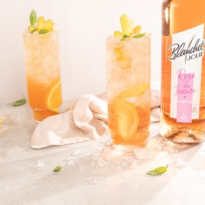 Die Cocktails in hohen Gläsern sind mit Eis gefüllt und zeigen eine Mischung aus orangefarbenen und gelben Tönen.